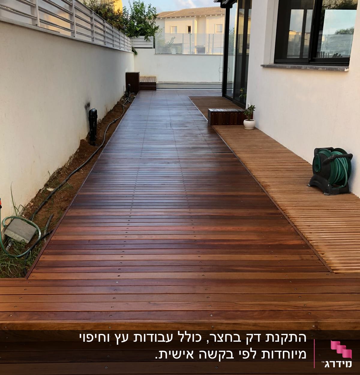 דק עץ חום עם צינור השקיה מגולגל